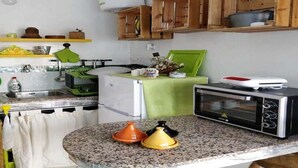 Eine Küche mit einer Granitabdeckung, einer Mikrowelle, einem Toasterofen, Holzschränken und einem grünen Tuch auf der Arbeitsplatte.