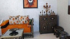 Ein Zimmer mit einer Couch, einem Schrank und einem Tisch.