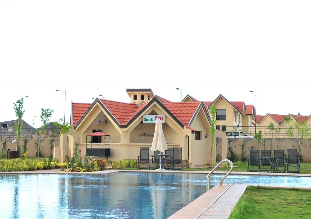 A swimming pool with a snack bar and a pizza restaurant in the background.