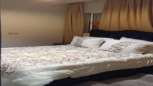 Ein Schlafzimmer mit Bett, Vorhängen und einer Deckenleuchte.