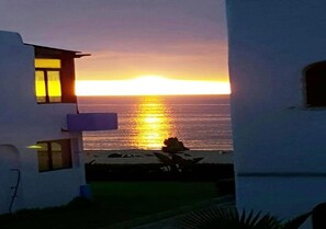 A building with a view of the sunset over the ocean.