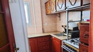 Eine kleine Küche mit Holzausstattung, einem Gasherd und einem Spülbecken.