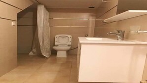 A bathroom with a toilet, sink, and shower curtain.