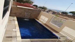 A swimming pool with a stone wall and a metal ladder. - Moroccan Surf Adventures 5185 (Imi Ouaddar)