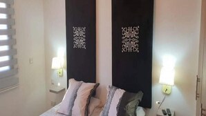 Un dormitorio con una cama, dos lámparas de noche y paneles decorativos en la pared.