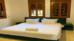 A large bed with a green headboard, white bedding, and a wooden wardrobe with glass doors. - Sublime villa with swimming pool in Marrakech 4814 (Marrakech)