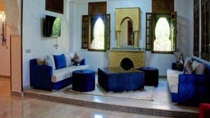 A room with a blue sofa set, a central fireplace, and a chandelier. - Sublime villa with swimming pool in Marrakech 4814 (Marrakech)