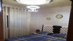 A bedroom with a bed, curtains, a clock, and a chandelier. - Nice apartment in Bella Vista 4815 (Cabo Negro)