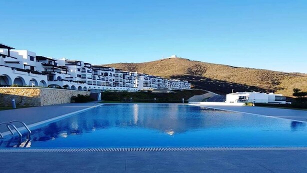 A swimming pool with a clear view of a white building with arches and a hilly landscape in the background. - Nice apartment in Bella Vista 4815 (Cabo Negro)
