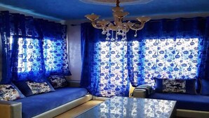 A living room with a sofa set, a glass coffee table, and a chandelier. - Nice apartment in Bella Vista 4815 (Cabo Negro)
