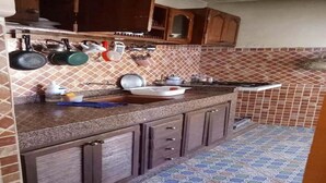 Eine Küche mit gefliestem Fliesenspiegel, Granit Arbeitsplatte und Holzausstattung.