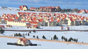 A snow-covered residential area with multiple buildings featuring red roofs. - Arz Village Farah Inn 4832 (Ifrane)