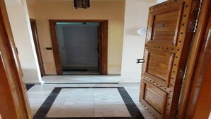 Un pasillo con una puerta de madera a la derecha y otra al final.
