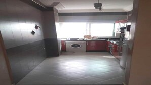 Una cocina con lavadora, fregadero y armarios.
