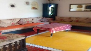 Una sala de estar con un sofá, una mesa de centro y una alfombra estampada.