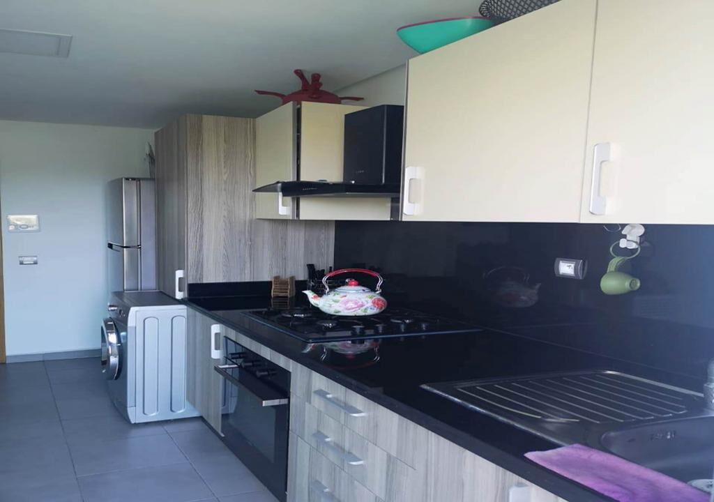 A modern kitchen with a built-in oven, a microwave, and a sink.