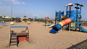 A beach playground with slides and climbing structures.