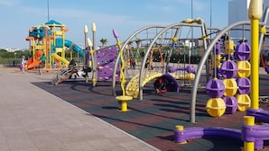 A playground with various play structures, including a slide and climbing frames. - Pleasant Apartment in Blanca Beach 4873 (Sidi Rahal)
