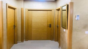Un pasillo con puertas de madera y una lámpara en el techo.