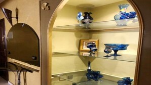 A glass display case with blue glassware and decorative items. - Residence Achraf Gueliz 4883 (Marrakech)