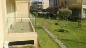 Een woongebouw met een balkon, een pad en een kleine tuin.