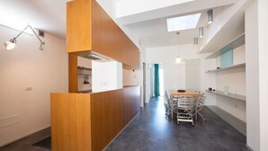 A modern kitchen with a wooden counter, a dining area with metal chairs, and a skylight. - WePuglia - Belvedere sul Porto (Monopoli)