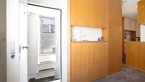 A modern kitchen with wooden cabinets, a built-in oven, and a countertop with a coffee maker. - WePuglia - Belvedere sul Porto (Monopoli)