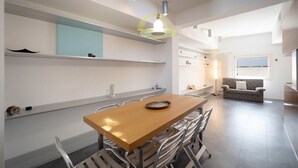 A modern kitchen with a wooden table, metal chairs, and built-in shelves. - WePuglia - Belvedere sul Porto (Monopoli)