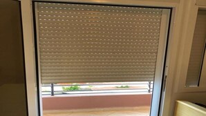 Ein Zimmer mit einer Schiebetür und einem Außenbalkon mit gefliestem Boden.