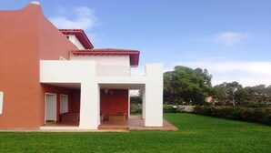 A modern two-story house with a red roof and white exterior walls, a front porch, and a well-maintained lawn. - Superb Villa in Marina Saidia 4899 (Saidia)