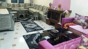 A living room with a sofa set, a coffee table, a television, and decorative rugs. - Beautiful apartment in Ifrane 4902 (Ifrane)