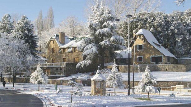 A stone building with snow-covered trees and a clear sky. - Beautiful apartment in Ifrane 4902 (Ifrane)