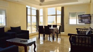 Un amplio salón con una mesa de comedor, sofás y una televisión.