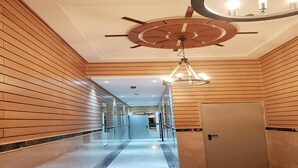 A hallway with wooden paneling, a ceiling fan, and a chandelier. - Beautiful apartment in Puerto Marina 4933 (Asilah)