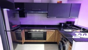 A compact kitchen with a built-in oven, a washing machine, and a sink. - Beautiful apartment in Puerto Marina 4933 (Asilah)