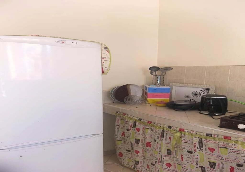 A kitchen with a white refrigerator, a coffee maker, and a microwave on the counter.