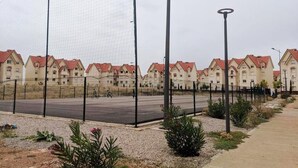 Un quartier résidentiel avec des maisons, une route et une clôture.