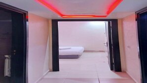 Un pasillo estrecho con una lámpara en el techo y una cama al fondo.
