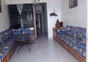 Uma sala de estar com sofá, mesa de centro e luminária decorativa.
