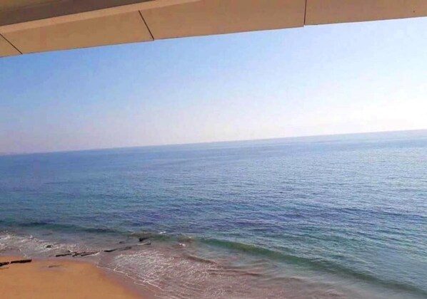 Uma praia com águas azul-claras e uma orla arenosa.