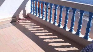A balcony with blue balusters and a tiled floor. - Pleasant Sea Front Apartment in Taghazout 4966 (Taghazout)