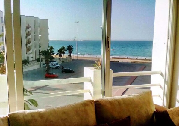 A balcony with a view of the sea and a building with a spiral staircase.