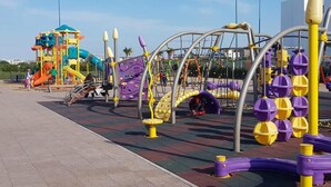 A playground with various play structures, including a slide and climbing frames.