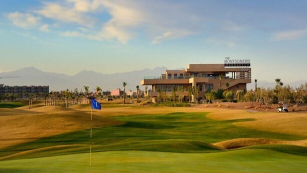 En golfbana med en modern byggnad som bär namnet ”The Montgomerie Golf”.