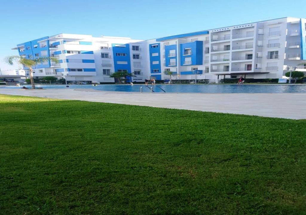 Ein modernes Hotel mit Poolbereich und Rasenfläche.