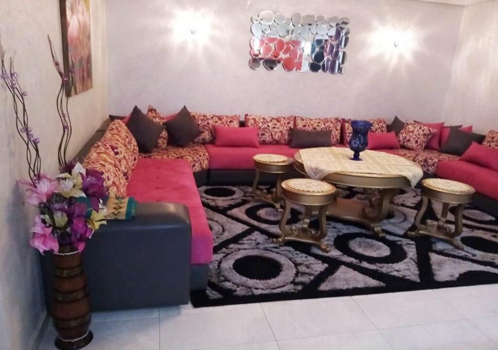 A living room with a sofa set, a coffee table, and a decorative mirror on the wall.