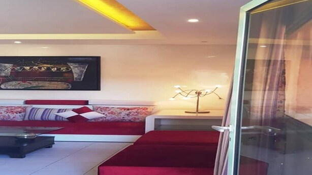 Een moderne woonkamer met een bank, een salontafel en een lamp.