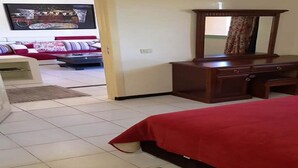 Een hotelkamer met een bed, een houten dressoir en een aan de muur bevestigde televisie.