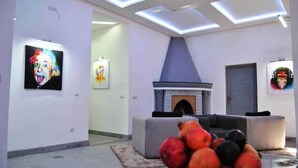 A modern living room with a fireplace, a sofa, and a fruit bowl. - Pleasant villa in Marrakech 5037 (Marrakech)