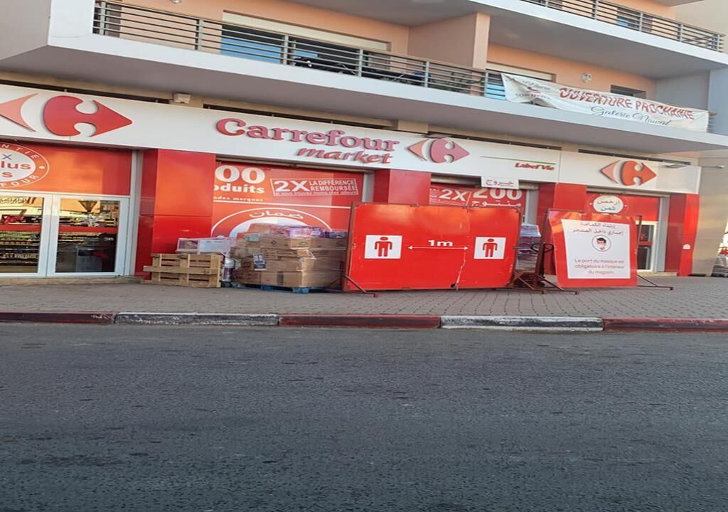 A Carrefour market with a prominent sign, a balcony, and a 2x2 promotional sign.